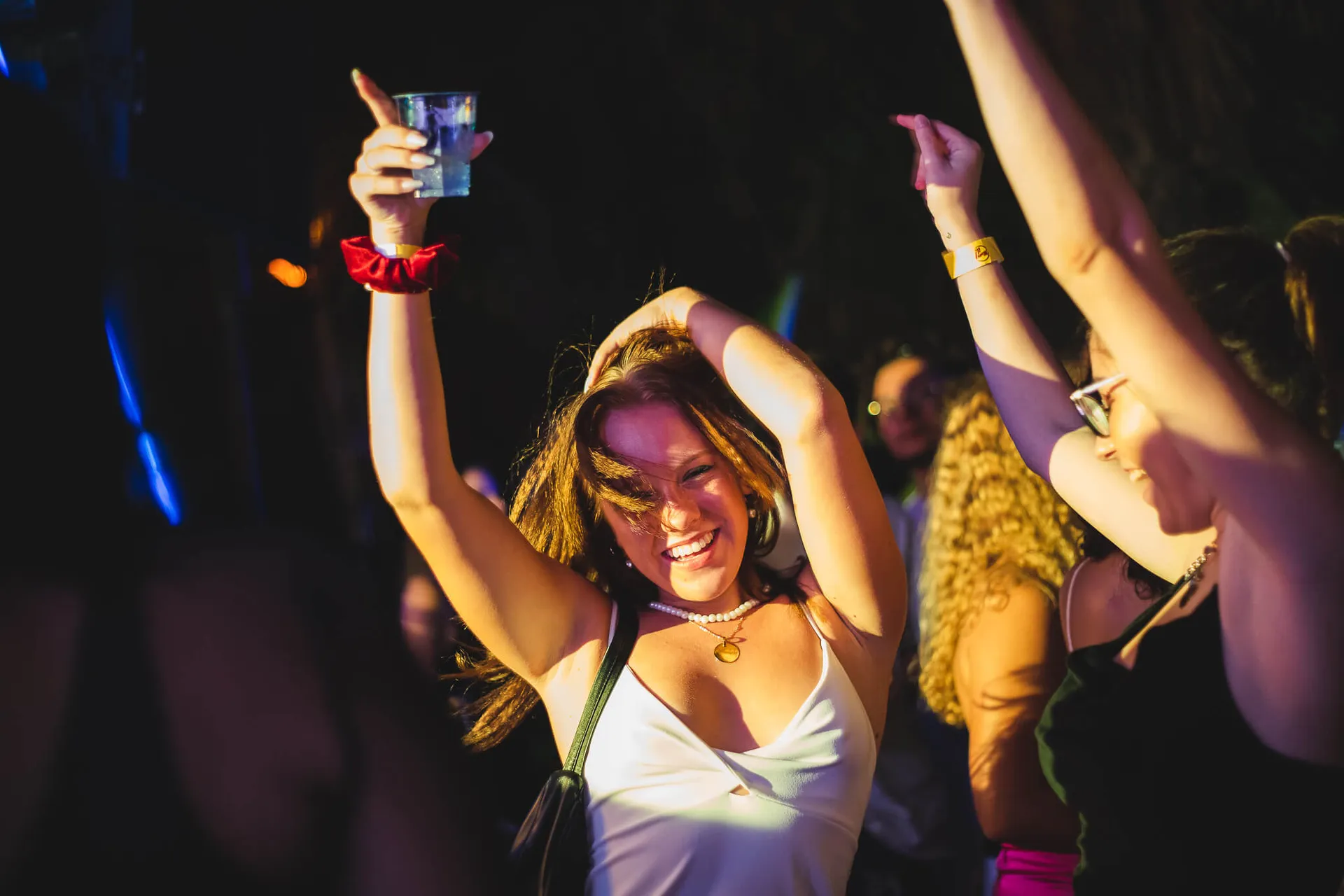 Girl dancing with her drink in the air at Move it! Malta