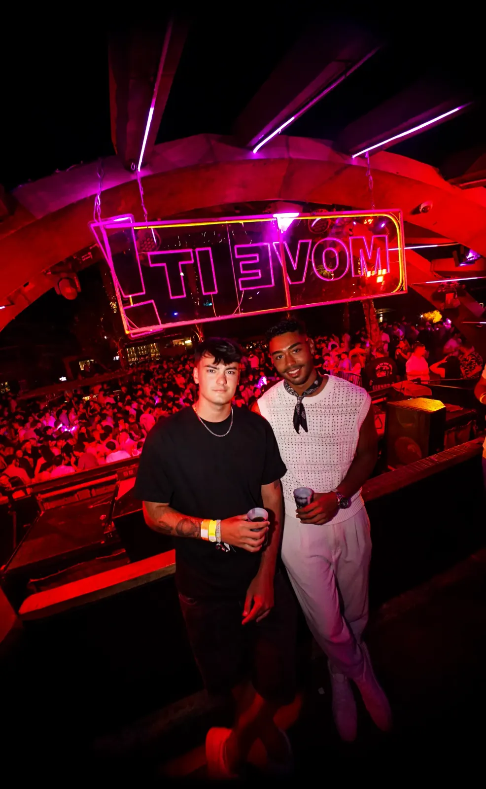 Partygoers in front of the red Move it! neon sign in the Main Room